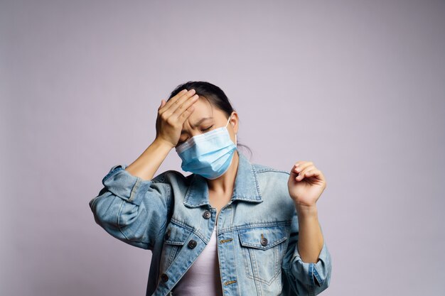 Asian woman wearing protective face mask was sick with headache isolated.
