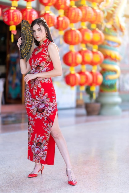 Asian woman wearing red cheongsam dress traditional decoration with paper lanterns with the Chinese alphabet Blessings written on it Is a Fortune blessing compliment for Chinese new year festival