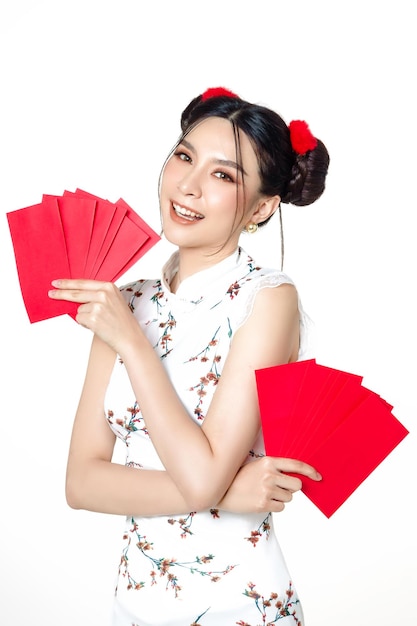 Asian woman wearing traditional cheongsam qipao dress holding angpao or red packet monetary gift