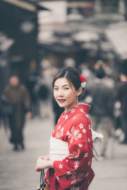 Asian woman wearing traditional Japanese kimono walking in the old town of Kyoto