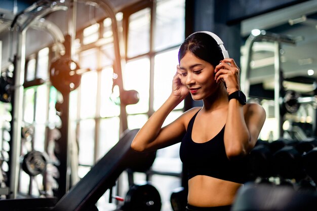 Asian woman wearing white workout clothes wearing headphones relax during exercise create energy for exercise fitness inspiration