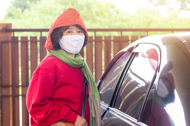 집을 떠나기 전에 수술 용 마스크를 쓴 아시아 여성, 코로나 19 감염 감소