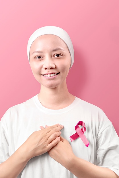 Asian woman in a white shirt with pink ribbon on pink