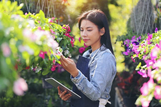 花園事業を営むアジアの女性が、顧客の注文に合わせて花を数えています。