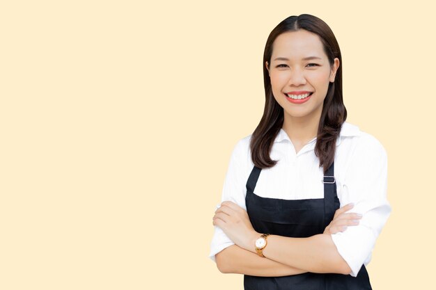 asian woman with apron standing isolated on cream color background