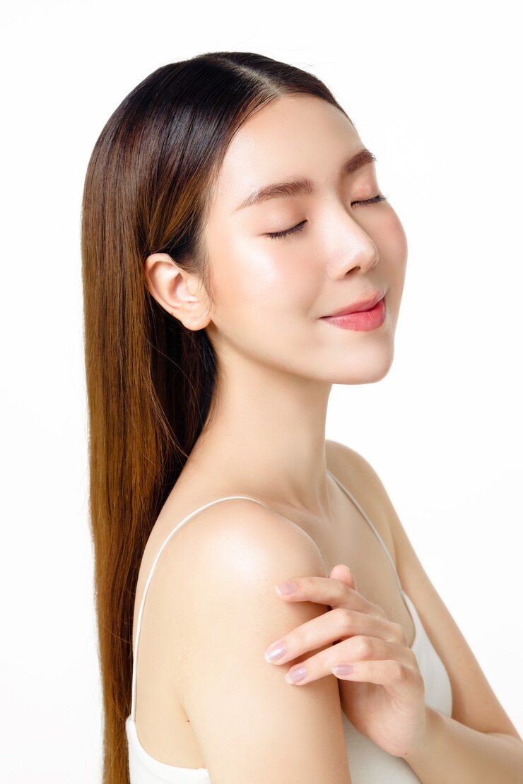 Photo 아름다운 얼굴과 신선한 피부를 가진 아시아 여성이 격리된 흰색 배경에서 카메라를 바라보고 있습니다.
