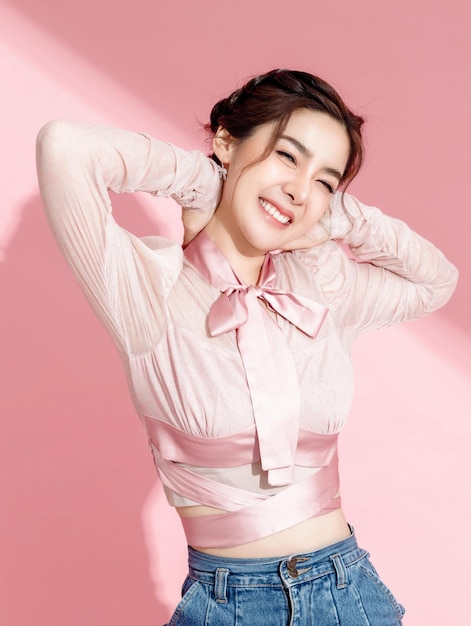 Азиатка с красивым лицом и свежей гладкой кожей на розовом изолированном фоне