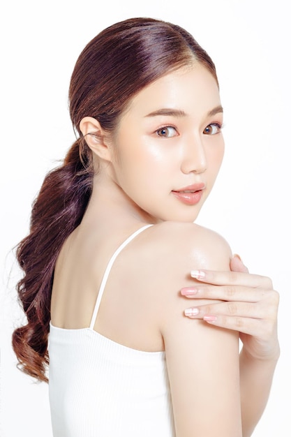 Asian woman with a beautiful face gathered in ponytail and fresh skin on white isolated background