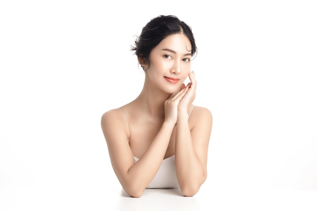 아름다운 얼굴과 깨끗하고 깨끗한 피부를 가진 아시아 여성 자연 화장과 흰색 외진 배경에 반짝이는 눈을 가진 귀여운 여성 모델 페이셜 트리트먼트 코스메탈로지 뷰티 컨셉