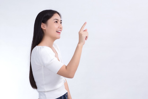 黒の長い髪のアジアの女性は白いシャツを着て、何かを提示するために彼女の手を指しています