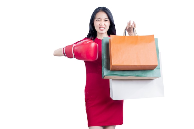 Asian woman with boxing glove carrying shopping bags isolated over white background