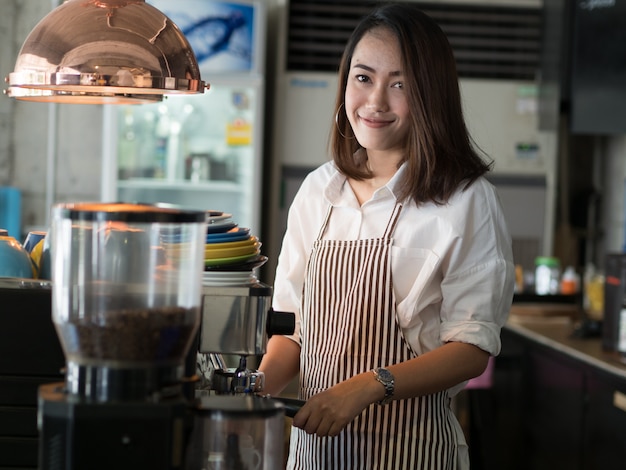 カフェでコーヒーを飲みながらアジアの女性