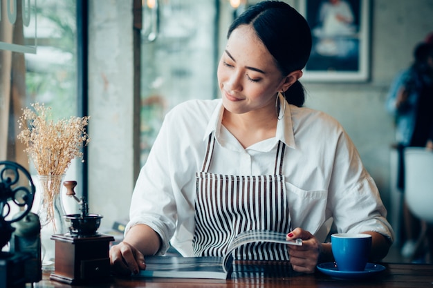 カフェでコーヒーを飲みながらアジアの女性