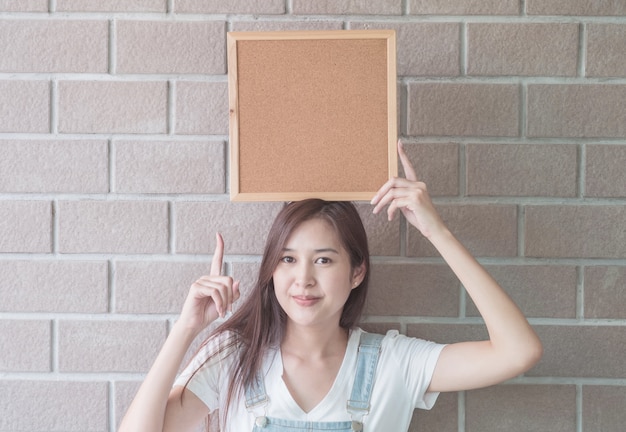 Asian woman with cork board in hand