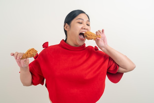 Asian woman with fried chicken on hand