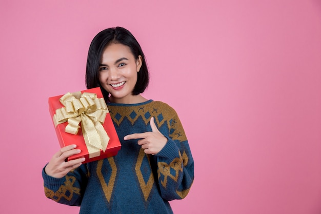 Asian woman with gift at pink backgrond.