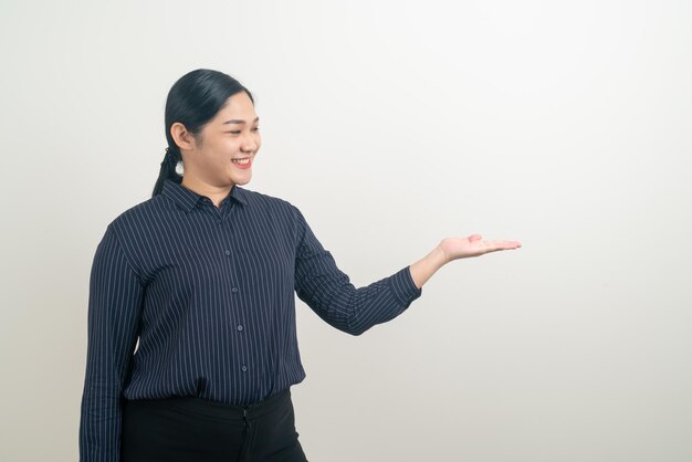 Asian woman with hand presenting on wall