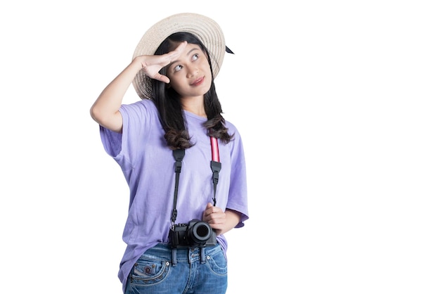 Donna asiatica con cappello e fotocamera guardando qualcosa di isolato su sfondo bianco