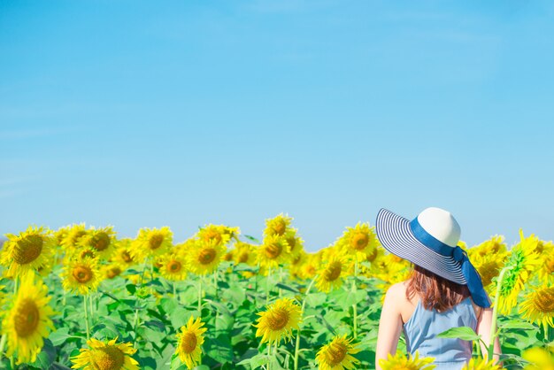 Photo asian woman with hat in a field of flowers, enjoying in sunflower field