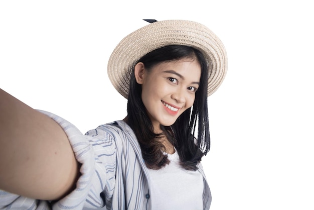 帽子をかぶったアジア人女性が自画像を撮る
