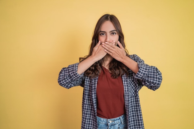 An asian woman with long hair covering her mouth with both hands with copyspace