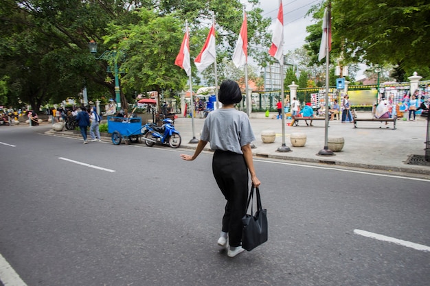 道路を横断する医療マスクを持つアジアの女性