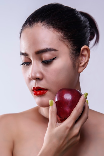 Asian woman with red apple in hand, health concept