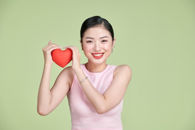 Asian woman with red heart on white background