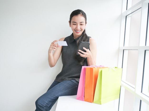 Asian woman with shopping bag in living room 