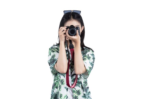 Asian woman with sunglasses using her camera standing