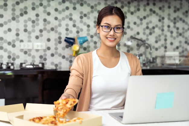 Photo asian woman work from home in the kitchen with delivery take away food