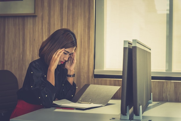 Donna asiatica per lavorare con lo stress in ufficio