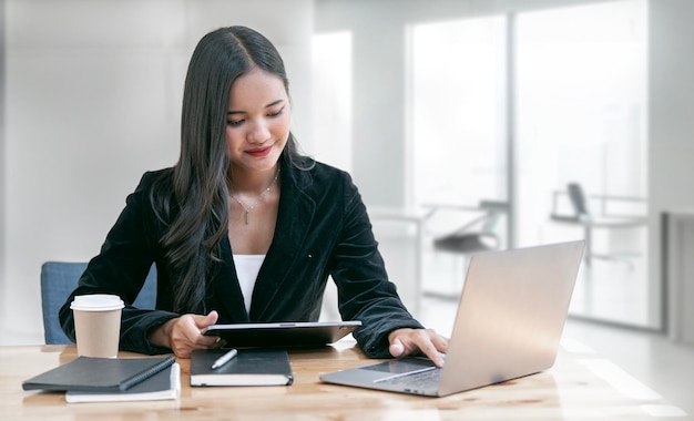 Asian woman working laptop Business woman busy working on laptop computer at office