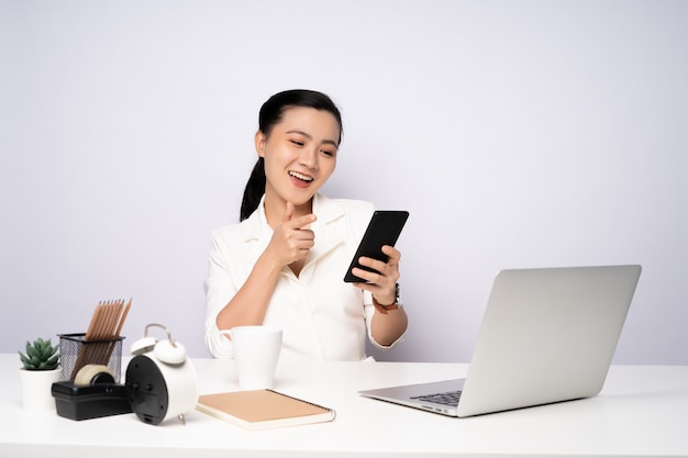 Asian woman working at officeusing smart phone for relaxing. Business with technology concepts.