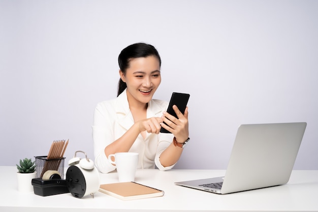 Asian woman working at officeusing smart phone for relaxing. Business with technology concepts.