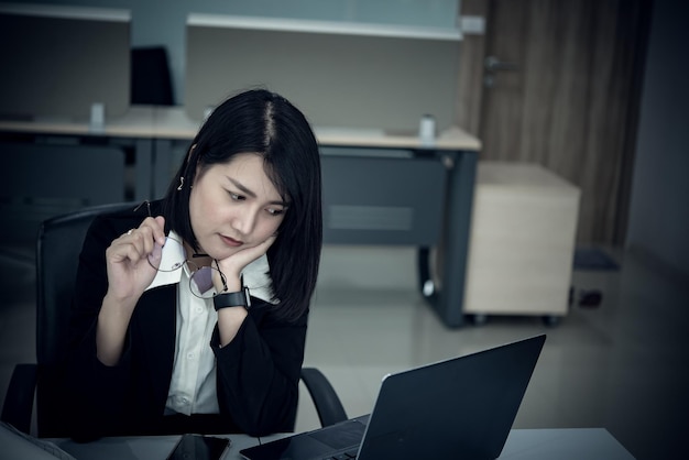 사무실에서 일하는 아시아 여성 젊은 비즈니스 여성은 책상에 많은 파일이 있는 업무 과부하로 스트레스를 받았습니다.태국 사람들은 무언가를 생각하고 있습니다.