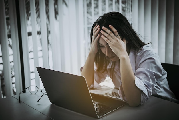 Asian woman working in officeyoung business woman stressed from work overload with a lot file on the deskThailand people