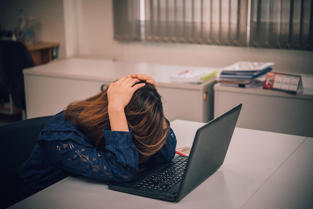 Asian woman working in officeyoung business woman stressed from work overload with a lot file on the deskThailand people