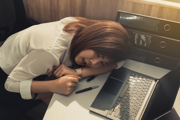 Foto donna asiatica che lavora in ufficio giovane donna d'affari stressata dal sovraccarico di lavoro con un sacco di file sul deskthailand persone