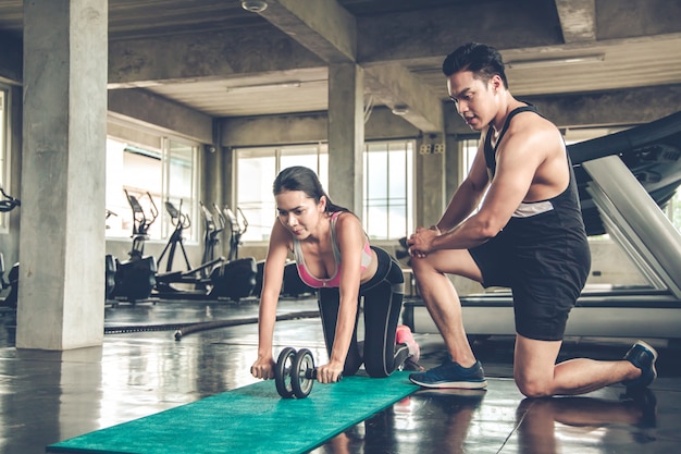 asian woman workout by ab wheel.