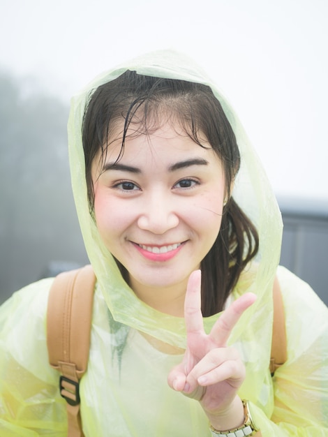 asian woman in yellow rainwear looking at the camera.