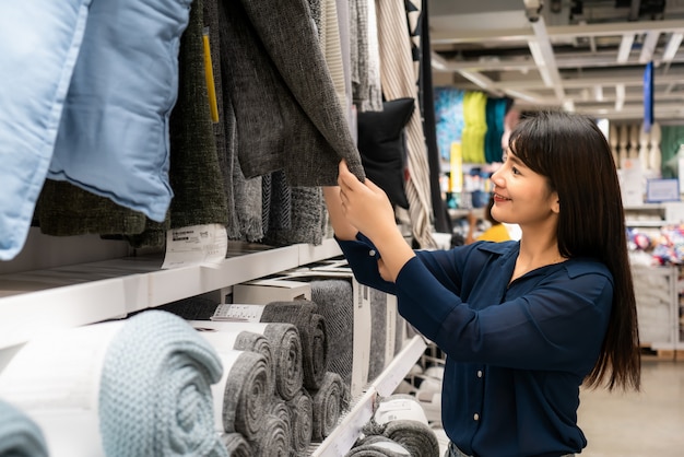 Asian women are choosing to buy new carpet in the mall. Shopping for groceries and housewares.