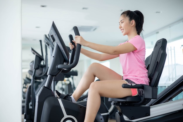 Asian women are exercising in the gym to sift through the leather water, keeping their body healthy. Premium Photo