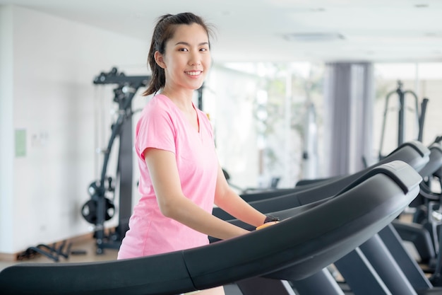 아시아 여성들은 몸을 건강하게 유지하면서 가죽 물을 걸러 내기 위해 체육관에서 운동하고 있습니다. 프리미엄 포토