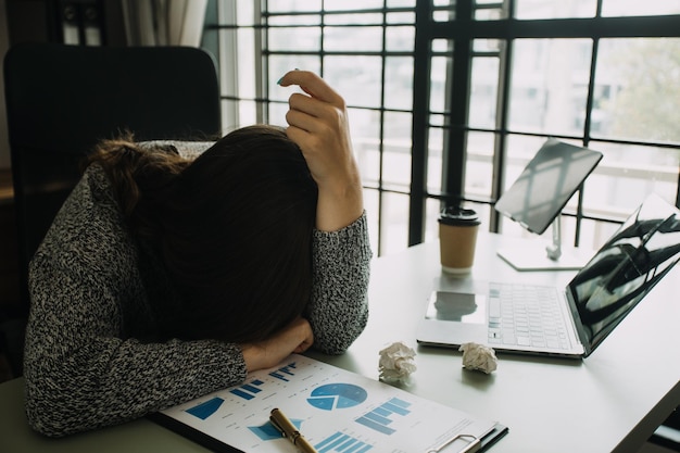 Asian women are stressed while working on laptop Tired asian businesswoman with headache at office feeling sick at work copy space