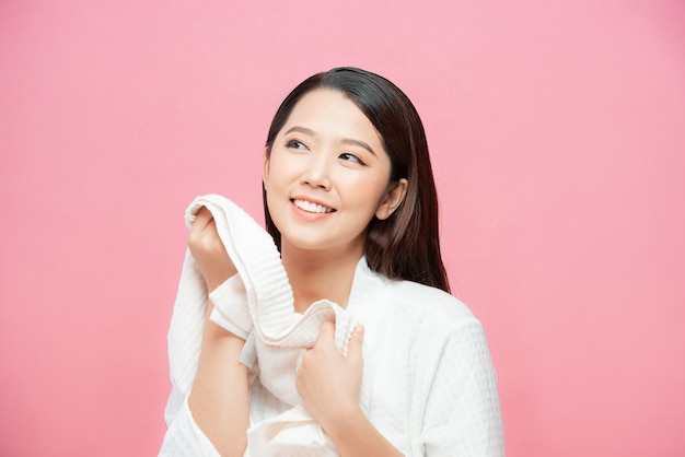 Азиатские женщины прикладывают к лицу сухое полотенце. после душа