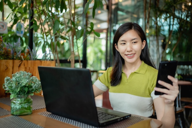 Asian women are using their laptops to work in coffee