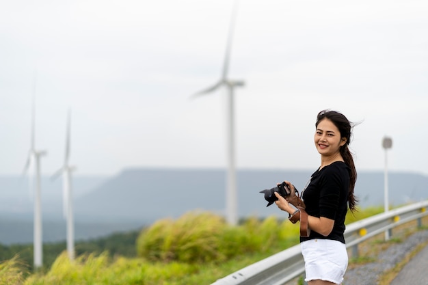 Asian women are very happy to photograph windmills and grasslands 