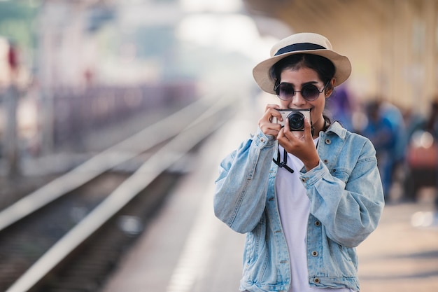 写真 アジアの女性は、旅行者のリラクゼーションconcで駅でカメラ旅行の休日に笑顔になります