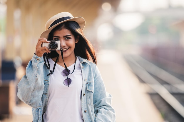 写真 アジアの女性は、旅行者のリラクゼーションconcで駅でカメラ旅行の休日に笑顔になります